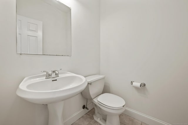 bathroom with tile patterned floors, toilet, and baseboards