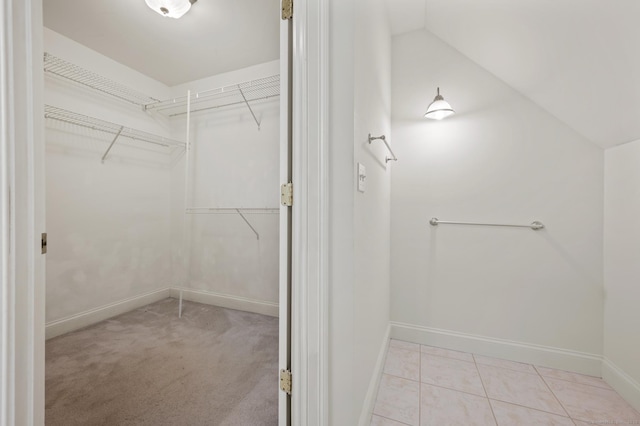 walk in closet featuring tile patterned flooring and lofted ceiling