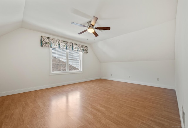 additional living space featuring a ceiling fan, light wood-style flooring, lofted ceiling, and baseboards