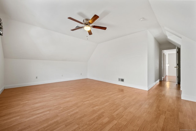bonus room with light wood finished floors, a ceiling fan, visible vents, vaulted ceiling, and baseboards