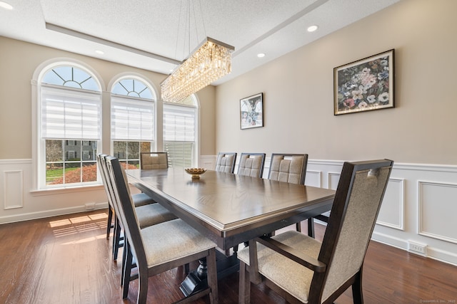 dining room with a textured ceiling, an inviting chandelier, recessed lighting, a decorative wall, and wainscoting