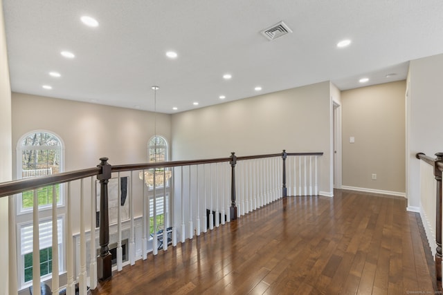 corridor with visible vents, recessed lighting, wood-type flooring, and baseboards