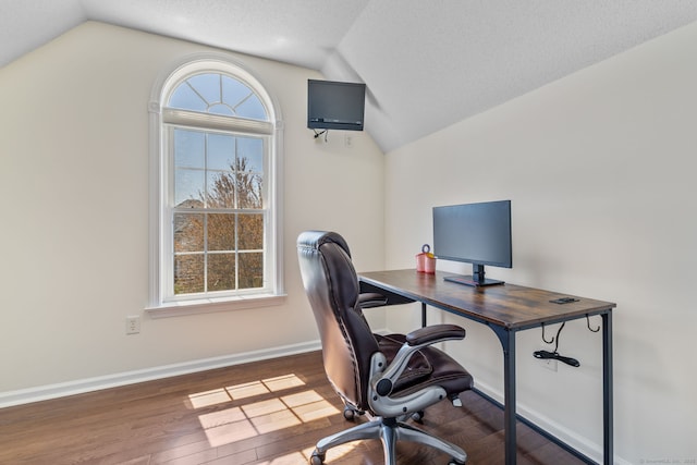 office space featuring a wealth of natural light, wood finished floors, and vaulted ceiling