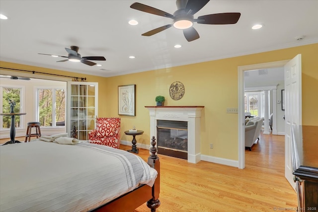 496 Foote Rd, Glastonbury, CT 06073 - bedroom with light wood-type flooring, recessed lighting, multiple windows, and a glass covered fireplace