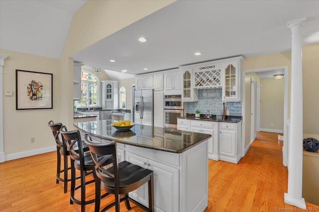 496 Foote Rd, Glastonbury, CT 06073 - kitchen featuring glass insert cabinets, a kitchen breakfast bar, backsplash, white cabinetry, and appliances with stainless steel finishes