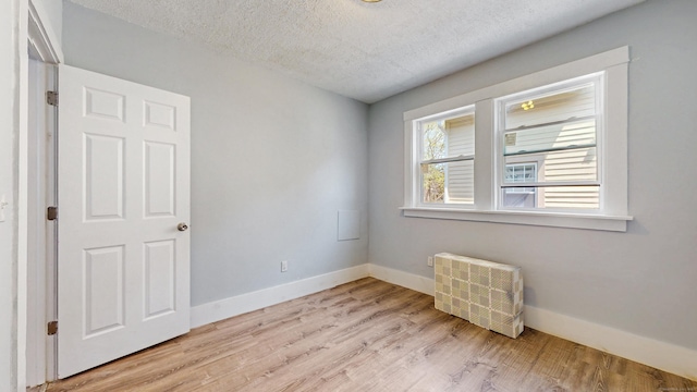 40 Penobscot St, Norwich, CT 06360 - unfurnished room featuring baseboards, light wood-type flooring, radiator, and a textured ceiling