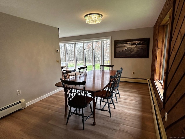 dining room featuring baseboards, a baseboard radiator, and wood finished floors