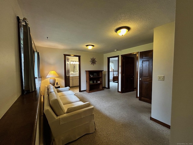 carpeted living room featuring baseboards and a textured ceiling