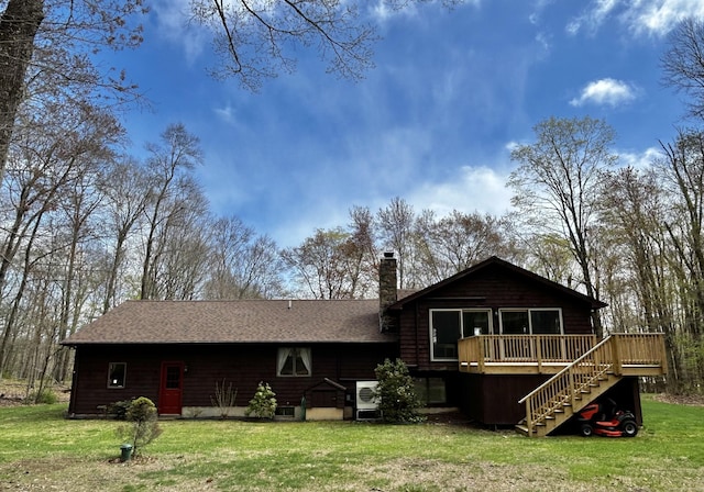 rear view of property with a chimney, a wooden deck, a yard, and stairway