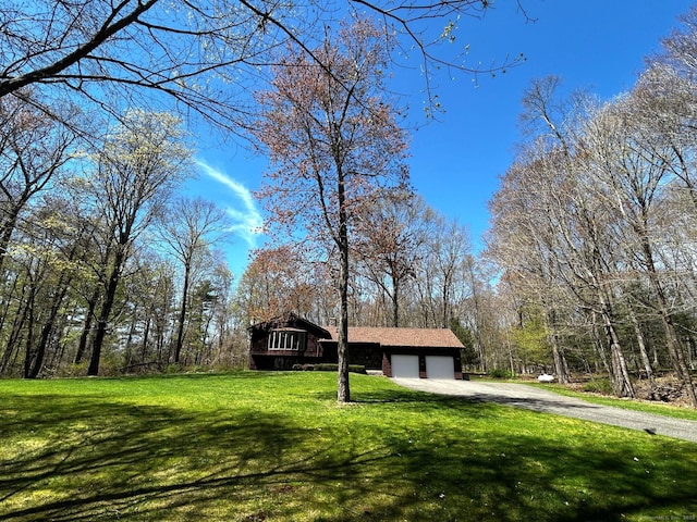 view of front of property with an attached garage, a front lawn, and dirt driveway