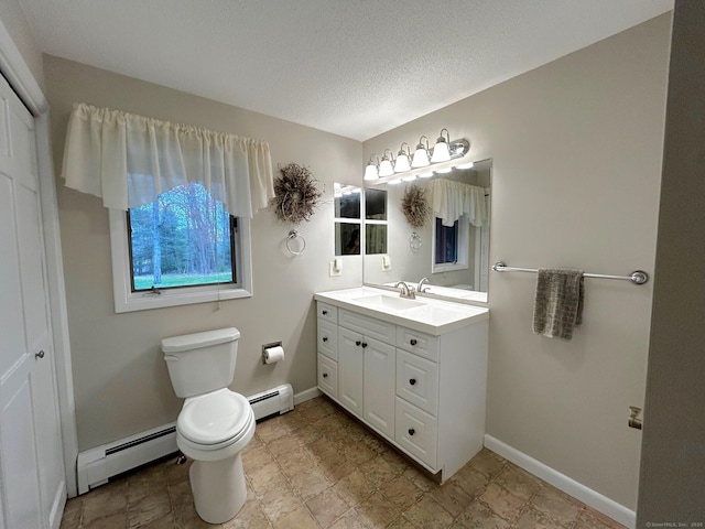 bathroom featuring toilet, baseboards, a baseboard heating unit, and vanity