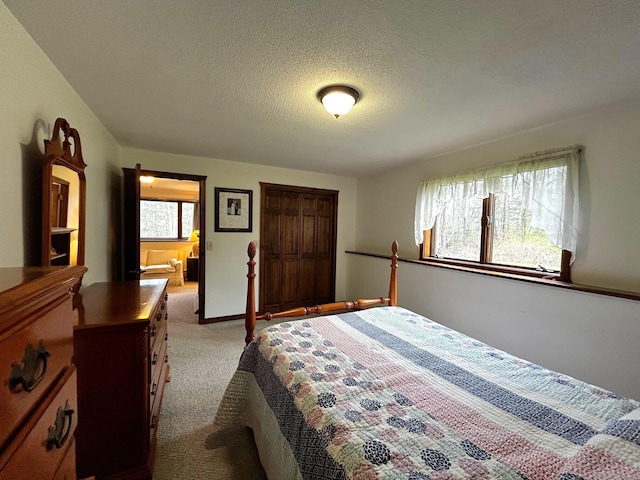 bedroom featuring a textured ceiling and light carpet