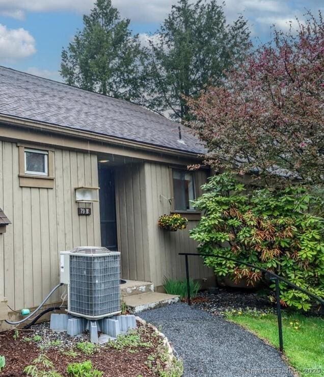 79 Heritage Vlg Unit B, Southbury, CT 06488 - view of side of home with a shingled roof and central AC unit