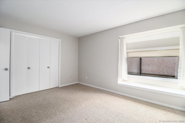 79 Heritage Vlg Unit B, Southbury, CT 06488 - unfurnished bedroom with a closet, carpet floors, and baseboards