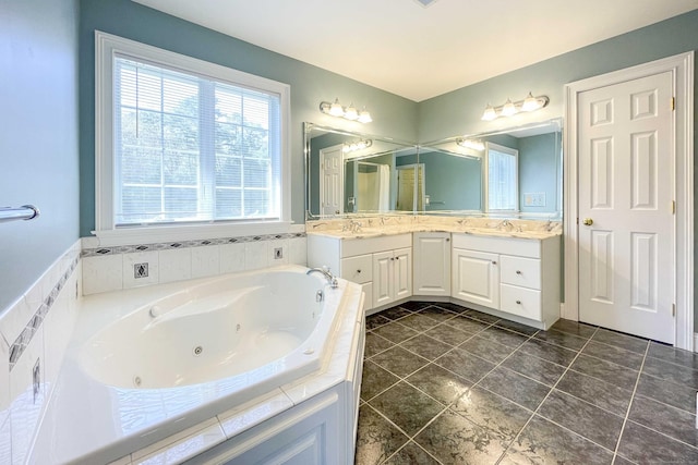 bathroom with double vanity, tile patterned flooring, a whirlpool tub, and a sink