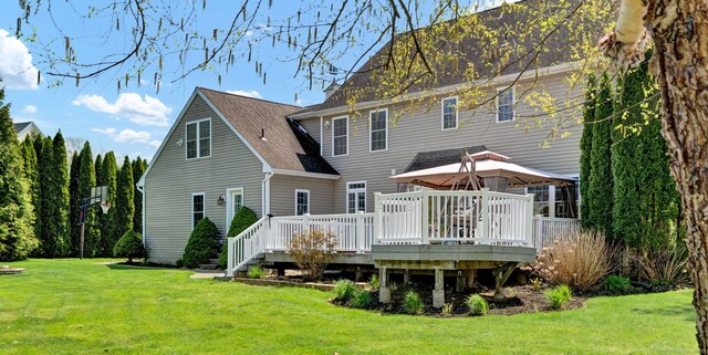rear view of house featuring a gazebo, roof with shingles, a wooden deck, and a yard