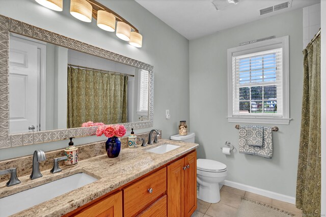 bathroom featuring visible vents, a sink, tile patterned floors, and toilet