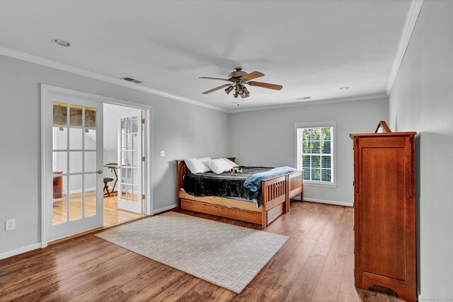 bedroom with wood-type flooring, baseboards, crown molding, and french doors