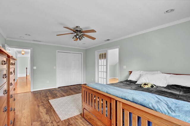 bedroom featuring crown molding, baseboards, visible vents, and wood finished floors