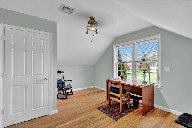 home office featuring a ceiling fan, visible vents, vaulted ceiling, wood finished floors, and baseboards