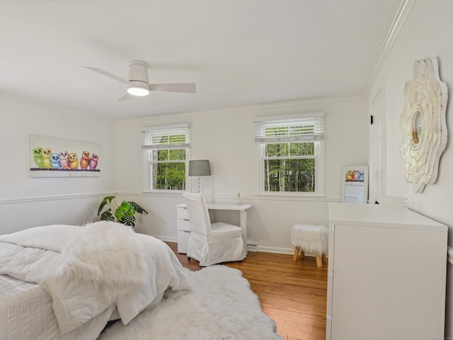 bedroom featuring baseboards, ornamental molding, ceiling fan, and wood finished floors