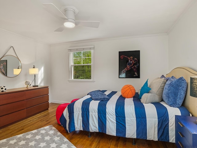 bedroom with baseboards, ornamental molding, ceiling fan, and wood finished floors
