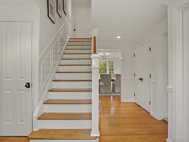 stairway with crown molding, recessed lighting, and wood finished floors