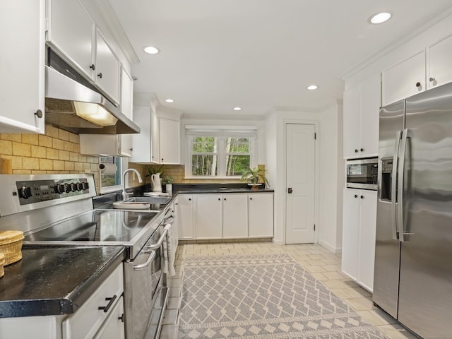 kitchen with decorative backsplash, under cabinet range hood, white cabinets, a sink, and appliances with stainless steel finishes