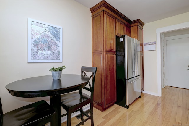 kitchen featuring freestanding refrigerator, baseboards, and light wood finished floors
