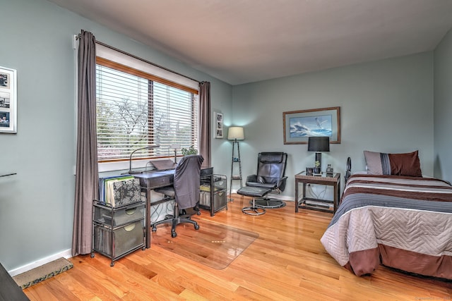bedroom with baseboards and wood finished floors