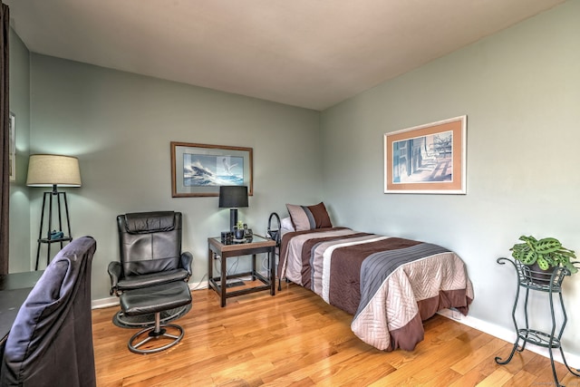 bedroom featuring light wood-style floors and baseboards