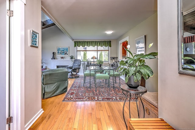 living room with baseboards, hardwood / wood-style flooring, and a fireplace