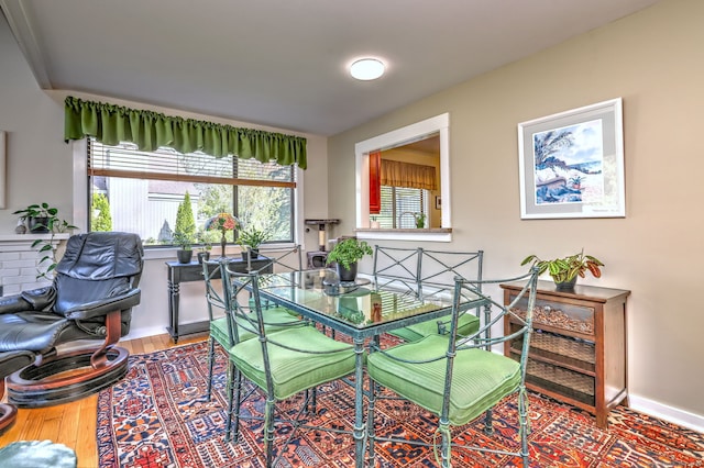 dining space featuring baseboards and wood finished floors