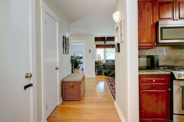 hall with baseboards and light wood finished floors