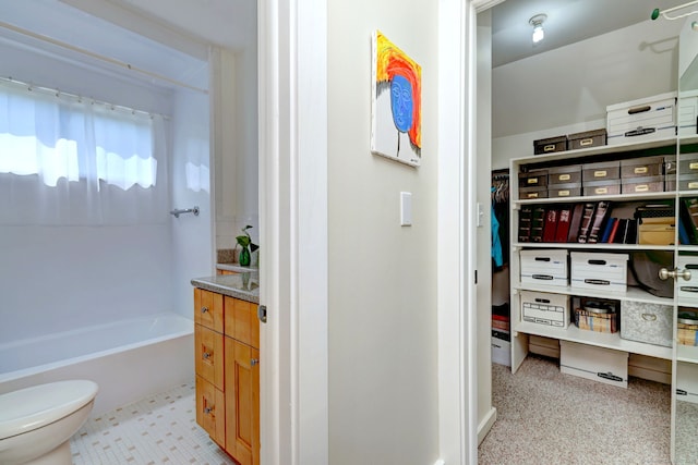 full bathroom with a bathing tub, toilet, and a spacious closet