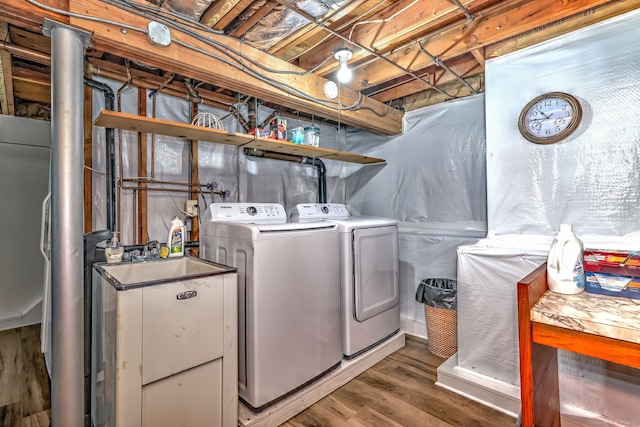 clothes washing area featuring laundry area, washer and clothes dryer, and wood finished floors