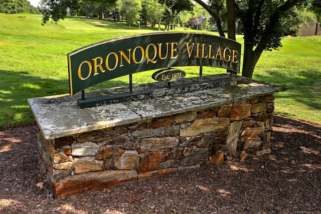 community / neighborhood sign with a yard