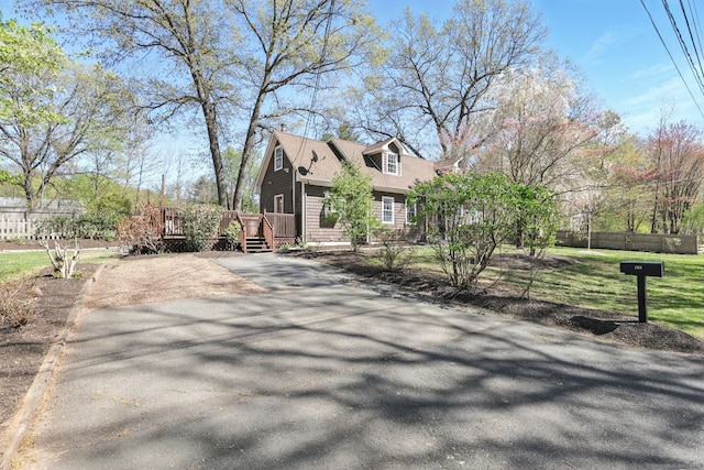view of home's exterior featuring a yard, fence, a wooden deck, and driveway