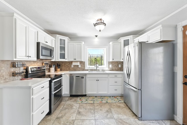 kitchen featuring glass insert cabinets, white cabinetry, tasteful backsplash, a sink, and appliances with stainless steel finishes