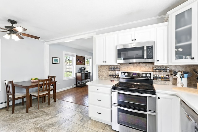 kitchen with light countertops, baseboards, tasteful backsplash, and stainless steel appliances