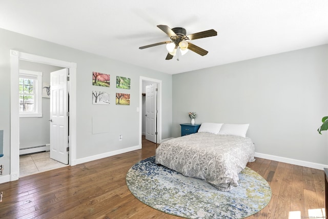 bedroom featuring baseboards, baseboard heating, and hardwood / wood-style flooring