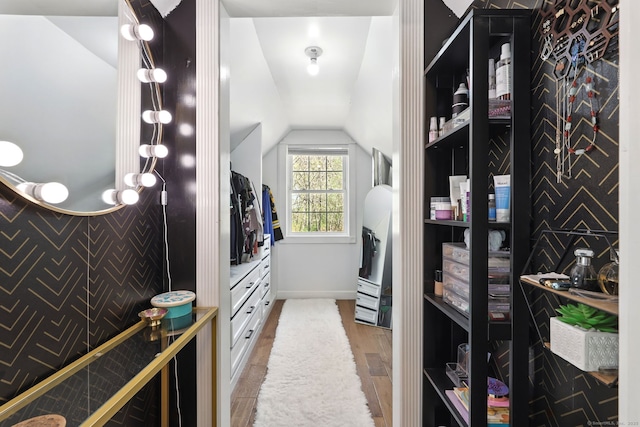 spacious closet with light wood finished floors and lofted ceiling