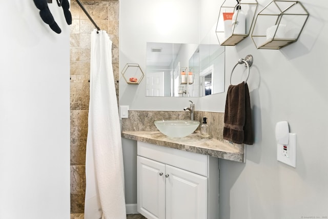 full bath with vanity and tiled shower
