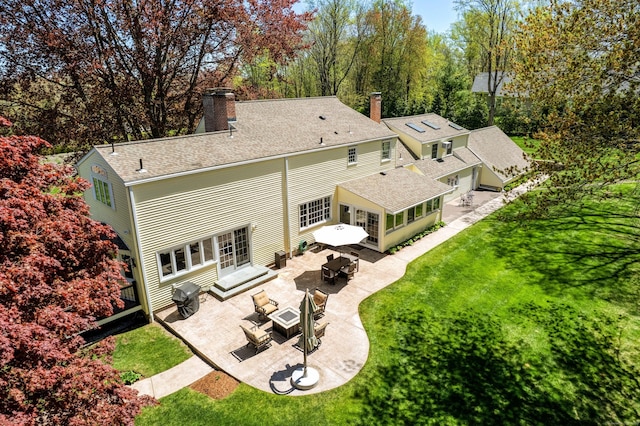 rear view of property featuring a patio, an outdoor living space with a fire pit, a chimney, a yard, and entry steps