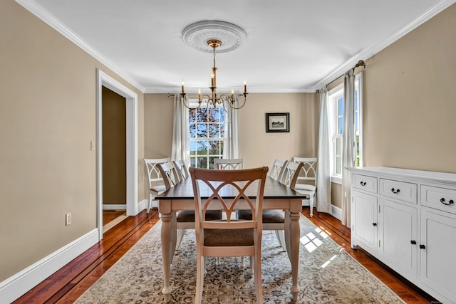 dining space featuring a chandelier, healthy amount of natural light, dark wood finished floors, and ornamental molding