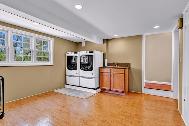 laundry area with washer and clothes dryer, cabinet space, light wood-type flooring, recessed lighting, and baseboards