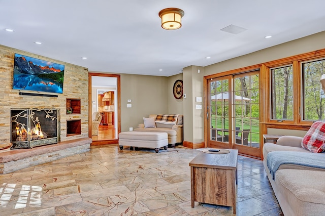 living room with recessed lighting, marble finish flooring, a stone fireplace, and baseboards
