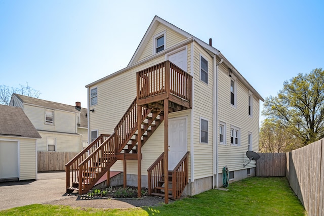 rear view of house with a yard, stairway, a fenced backyard, entry steps, and a wooden deck
