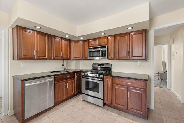 kitchen with recessed lighting, appliances with stainless steel finishes, light tile patterned floors, and a sink