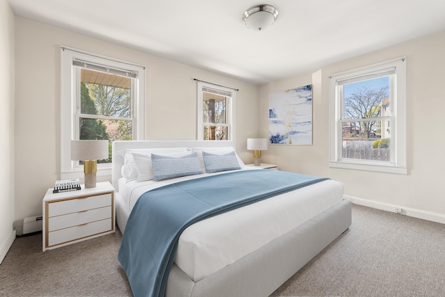 bedroom with carpet flooring, baseboards, and a baseboard heating unit
